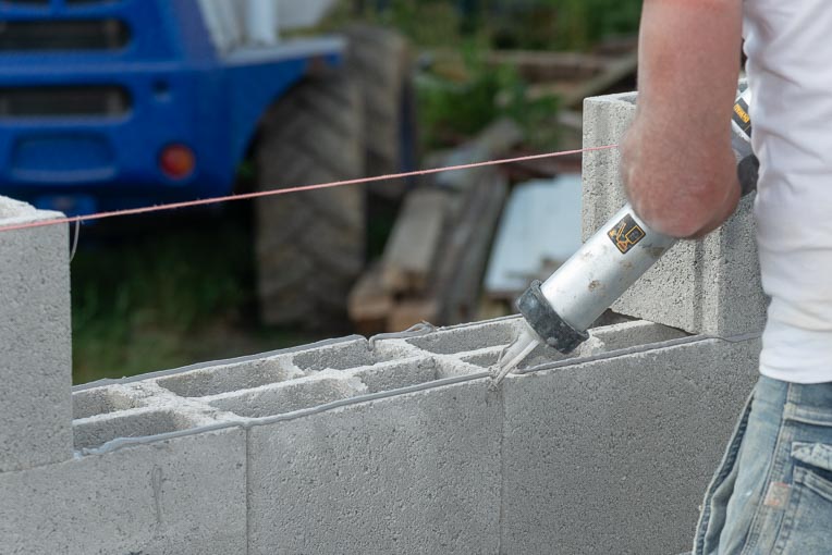Mise en place blocs béton rectifiés par collage au pistolet. [©ACPresse]